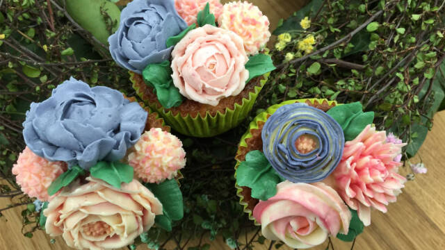muffins pyntet med smørblomster i forskellige farver