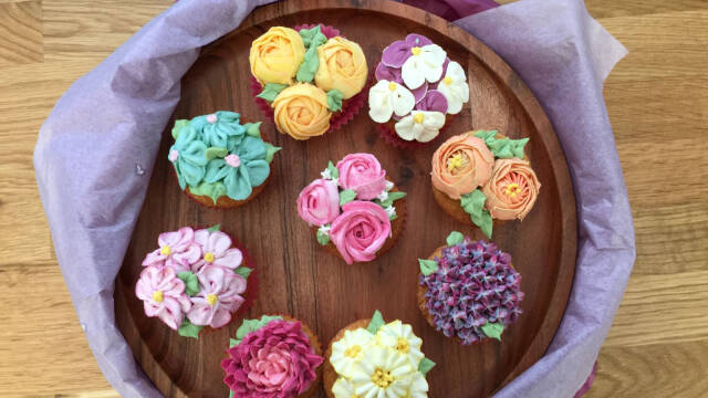 farverige cupcakes med smørblomster på træfad