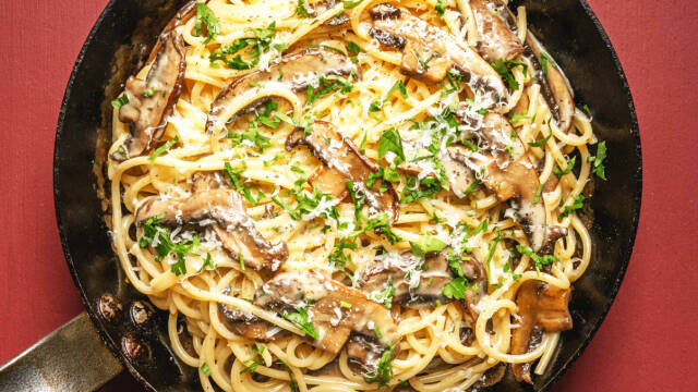 En pande med spaghetti carbonara med svampe og persille.