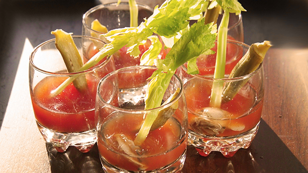 Billedet viser fire tevodka-drinks pyntet med citrongræs.