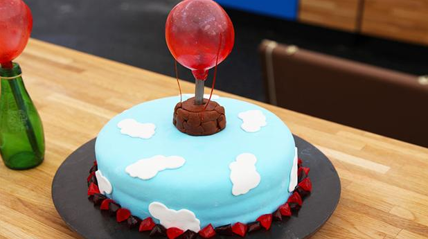 Fødselsdagskage med forskellig farvede bunde og ballon på toppen