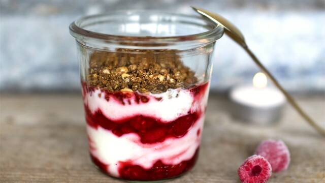 Nem og hurtig yoghurtdessert med hindbær og sprødt drys.