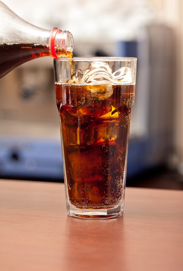 Colaflaske hælder op i glas