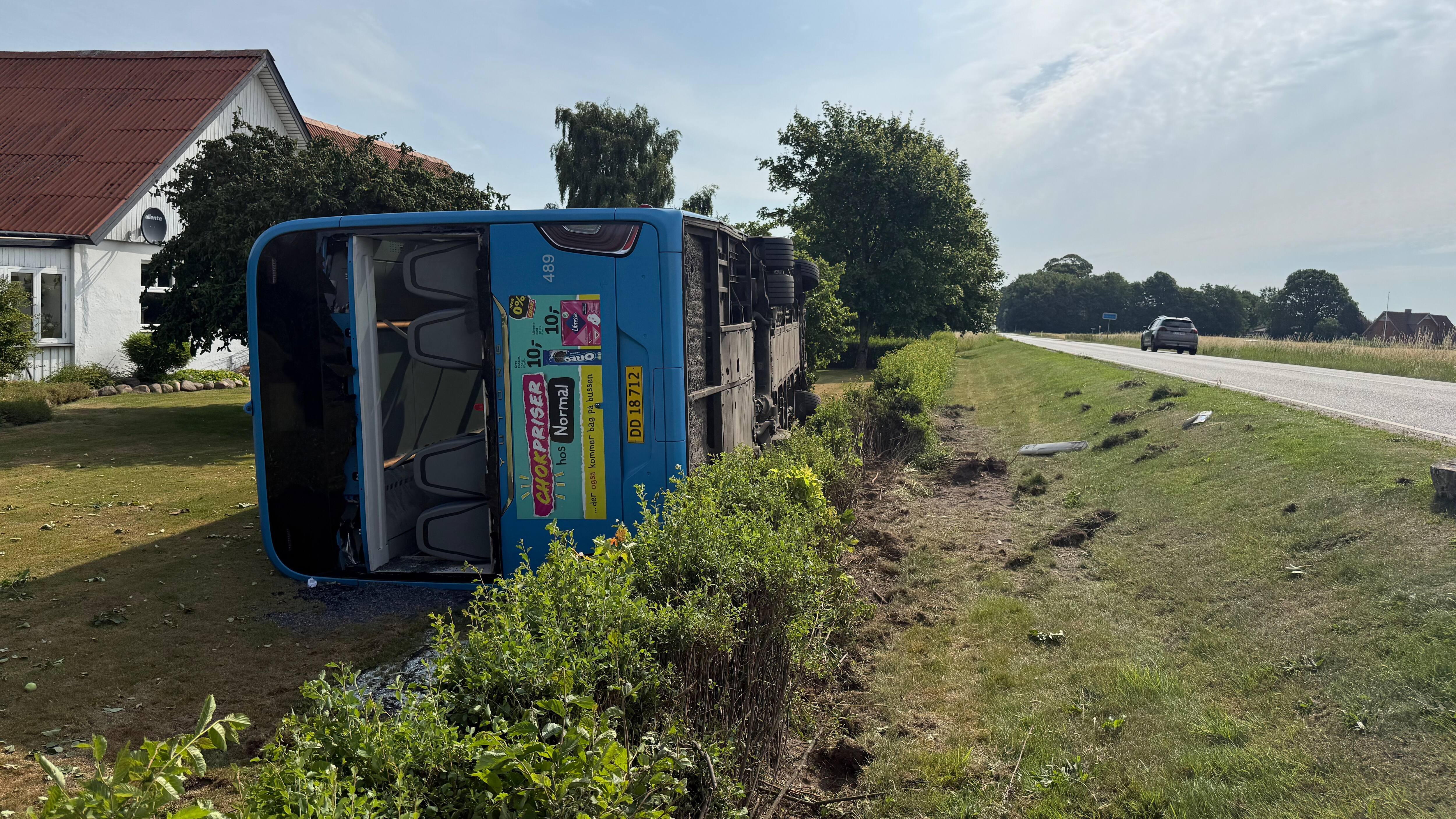 Bus væltet ind i have