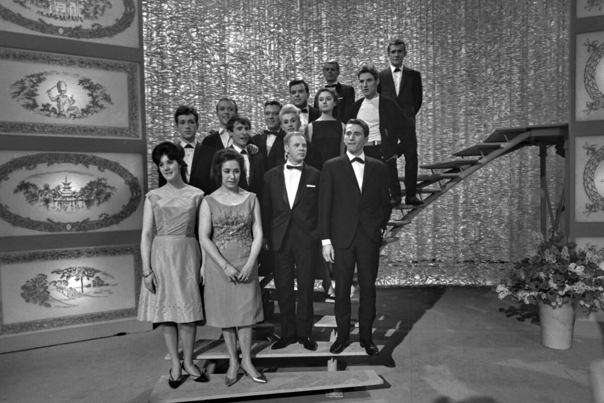 Foto de todos los participantes del Festival de Eurovisión 1964. Se encuentran en el escenario, específicamente en la parte derecha junto a una escalera de caracol por la que bajaban cuando les tocaba el turno de actuar. 